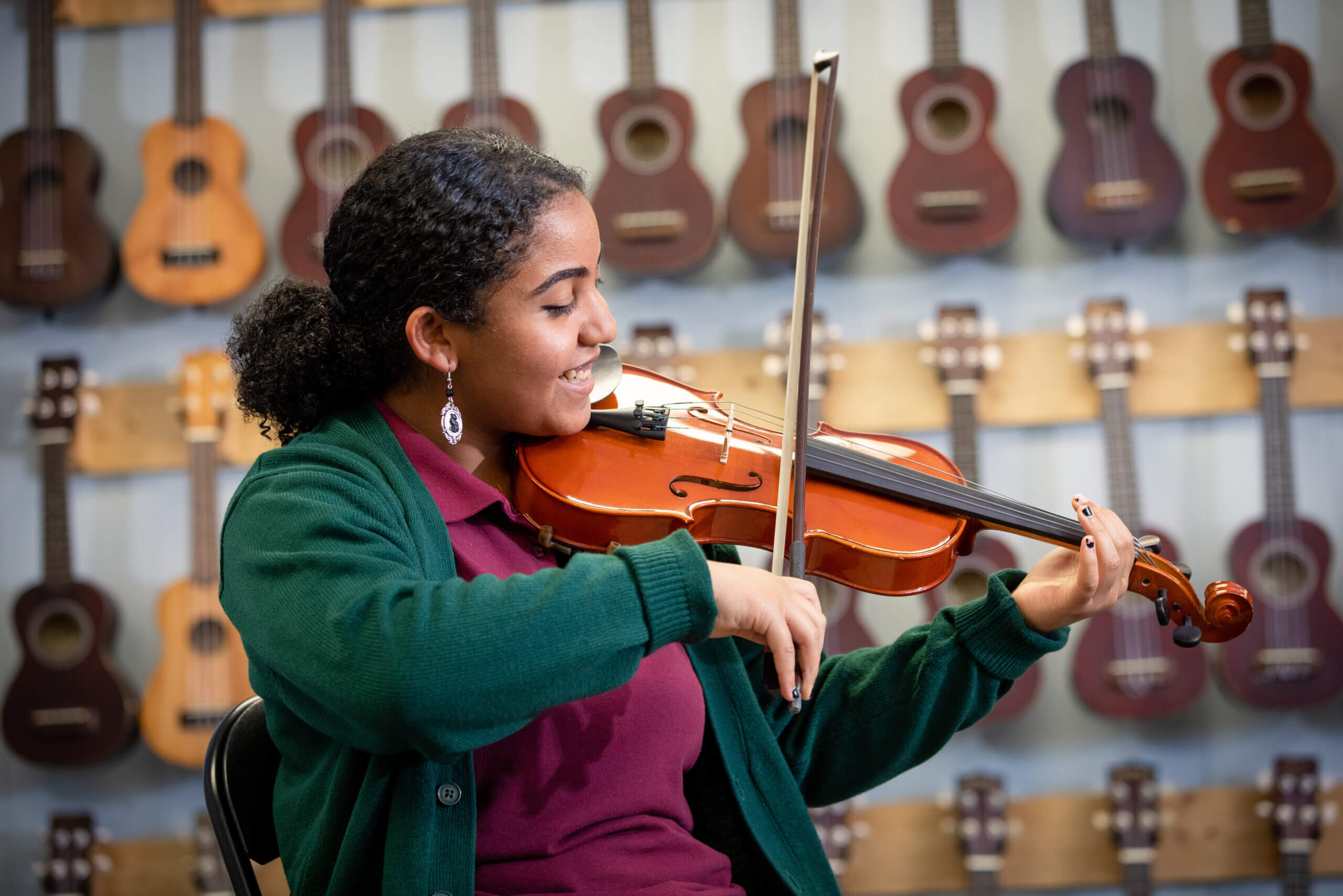 Photo of Four Corners Montessori student playing the violin in their music course